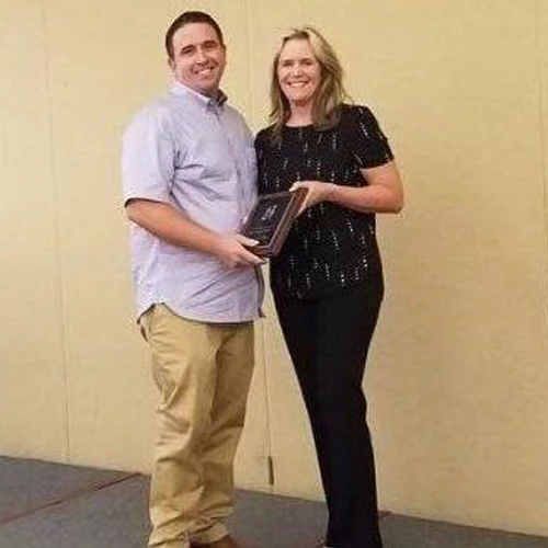 Two conference participants holding an award.