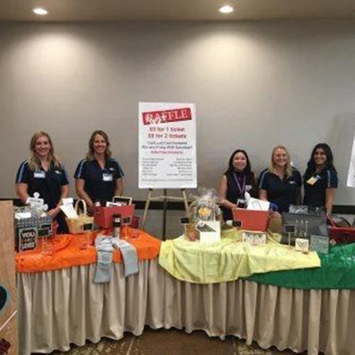 Conference volunteers behind a raffle table.