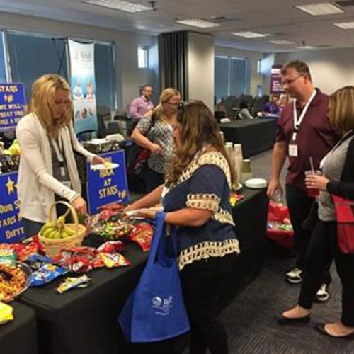 Attendees talking with exhibitors at a past conference.